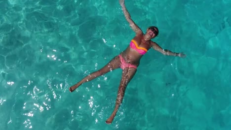 Beautiful-girl-is-laying-in-clear-blue-water-of-Maldivian-lagoon