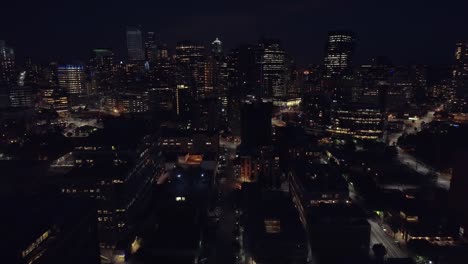 Helicopter-Pan-Up-to-Reveal-Skyscraper-Buildings-in-City-at-Night