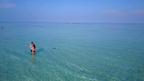 v03989-fliegenden-Drohne-Luftaufnahme-der-Malediven-weißen-Sandstrand-2-Personen-junges-Paar-Mann-Frau-romantische-Liebe-auf-sonnigen-tropischen-Inselparadies-mit-Aqua-blau-Himmel-Meer-Wasser-Ozean-4k