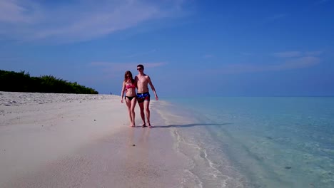 v03872-vuelo-drone-vista-aérea-de-Maldivas-playa-2-personas-pareja-hombre-mujer-amor-romántico-en-la-isla-de-paraíso-tropical-soleado-con-cielo-azul-aqua-agua-mar-4k