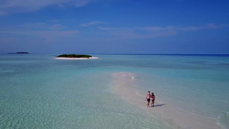 v03892-vuelo-drone-vista-aérea-de-Maldivas-playa-2-personas-pareja-hombre-mujer-amor-romántico-en-la-isla-de-paraíso-tropical-soleado-con-cielo-azul-aqua-agua-mar-4k