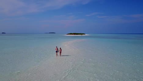 v03886-vuelo-drone-vista-aérea-de-Maldivas-playa-2-personas-pareja-hombre-mujer-amor-romántico-en-la-isla-de-paraíso-tropical-soleado-con-cielo-azul-aqua-agua-mar-4k