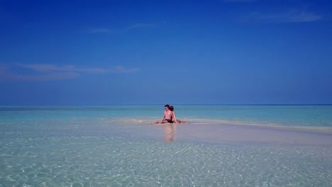 v03985-fliegenden-Drohne-Luftaufnahme-der-Malediven-weißen-Sandstrand-2-Personen-junges-Paar-Mann-Frau-romantische-Liebe-auf-sonnigen-tropischen-Inselparadies-mit-Aqua-blau-Himmel-Meer-Wasser-Ozean-4k