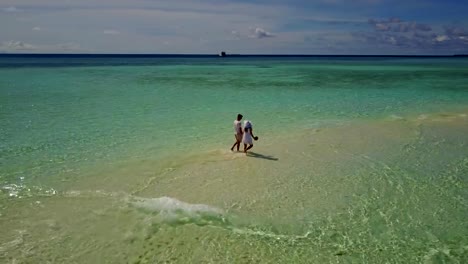 v03905-vuelo-drone-vista-aérea-de-Maldivas-playa-2-personas-pareja-hombre-mujer-amor-romántico-en-la-isla-de-paraíso-tropical-soleado-con-cielo-azul-aqua-agua-mar-4k