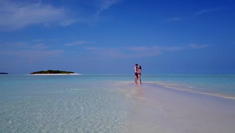 v03883-fliegenden-Drohne-Luftaufnahme-der-Malediven-weißen-Sandstrand-2-Personen-junges-Paar-Mann-Frau-romantische-Liebe-auf-sonnigen-tropischen-Inselparadies-mit-Aqua-blau-Himmel-Meer-Wasser-Ozean-4k