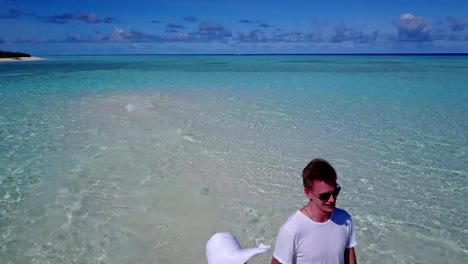 v03921-vuelo-drone-vista-aérea-de-Maldivas-playa-2-personas-pareja-hombre-mujer-amor-romántico-en-la-isla-de-paraíso-tropical-soleado-con-cielo-azul-aqua-agua-mar-4k