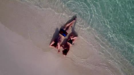 v03997-vuelo-drone-vista-aérea-de-Maldivas-playa-2-personas-pareja-hombre-mujer-amor-romántico-en-la-isla-de-paraíso-tropical-soleado-con-cielo-azul-aqua-agua-mar-4k