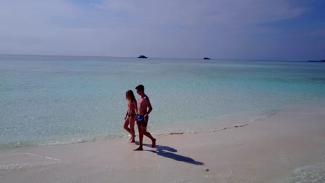 v03956-vuelo-drone-vista-aérea-de-Maldivas-playa-2-personas-pareja-hombre-mujer-amor-romántico-en-la-isla-de-paraíso-tropical-soleado-con-cielo-azul-aqua-agua-mar-4k