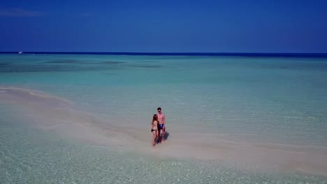 v03863-vuelo-drone-vista-aérea-de-Maldivas-playa-2-personas-pareja-hombre-mujer-amor-romántico-en-la-isla-de-paraíso-tropical-soleado-con-cielo-azul-aqua-agua-mar-4k