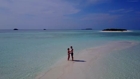 v03881-vuelo-drone-vista-aérea-de-Maldivas-playa-2-personas-pareja-hombre-mujer-amor-romántico-en-la-isla-de-paraíso-tropical-soleado-con-cielo-azul-aqua-agua-mar-4k