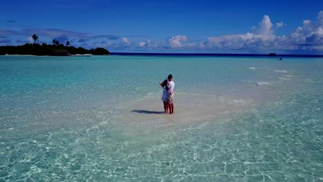 v03931-vuelo-drone-vista-aérea-de-Maldivas-playa-2-personas-pareja-hombre-mujer-amor-romántico-en-la-isla-de-paraíso-tropical-soleado-con-cielo-azul-aqua-agua-mar-4k