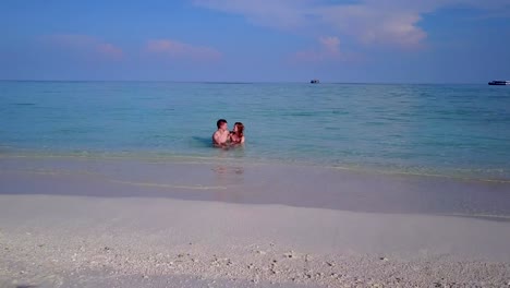 v03968-vuelo-drone-vista-aérea-de-Maldivas-playa-2-personas-pareja-hombre-mujer-amor-romántico-en-la-isla-de-paraíso-tropical-soleado-con-cielo-azul-aqua-agua-mar-4k