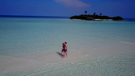 v03894-fliegenden-Drohne-Luftaufnahme-der-Malediven-weißen-Sandstrand-2-Personen-junges-Paar-Mann-Frau-romantische-Liebe-auf-sonnigen-tropischen-Inselparadies-mit-Aqua-blau-Himmel-Meer-Wasser-Ozean-4k