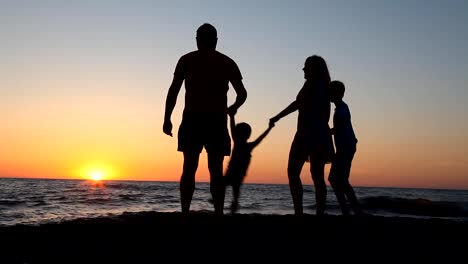 Familie-Silhouette-bei-Sonnenuntergang-in-der-Nähe-von-dem-Meer-Mutter-Vater-Kinder