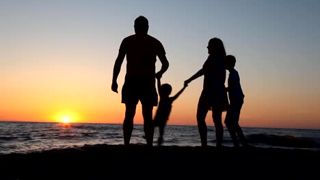 family-silhouette-at-sunset-near-the-sea-mother-dad-Kids