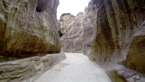 Touristen-zu-Fuß-entlang-des-Canyons-in-Petra.-Blick-auf-die-Stadt-Petra-in-Jordanien.-Touristische-Route-von-Petra-in-Jordanien.-Geschnitzte-Stadt-in-den-Bergen.