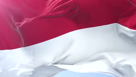 Indonesian-flag-waving-at-wind-in-slow-in-blue-sky,-loop