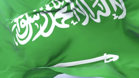 Saudi-Arabia-flag-waving-at-wind-in-slow-with-blue-sky,-loop