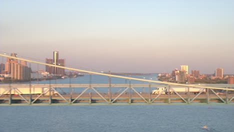 AERIAL-Semi-trucks-crossing-highway-bridge-transporting-goods-from-Canada-to-USA