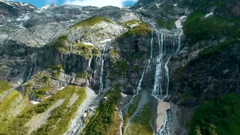 Epopeya-aérea-cerca-de-la-cascada-de-montañas-en-Groenlandia