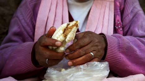 eine-Frau-und-Riesen-Mais-auf-einem-Straßenmarkt-in-cuzco