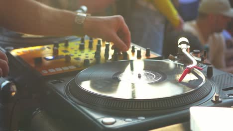 close-up-dj-hand-scratching-vinyl-record-on-turntable-on-a-party