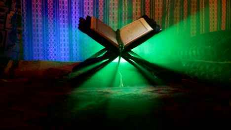 Open-holy-book-of-Muslims-on-stand-on-eastern-carpet-with-dark-toned-foggy-background.-Muslim-religion-concept.-Selective-focus.-Slider-shot.