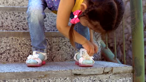 A-little-girl-is-wiping-her-sandals.