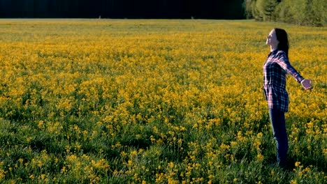 Morena-mujer-camina-en-el-campo-de-flores-amarillas.-Se-estira-y-respira-profundamente.