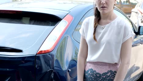 frustrated-brunette-woman-is-standing-near-a-broken-car