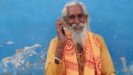 Closeup-of-an-excited-Hindu-holy-man-communicating-on-a-touch-screen-phone