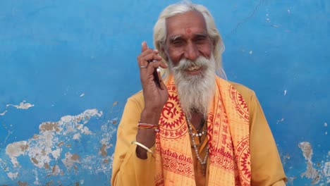 Closeup-de-un-hombre-Santo-hindú-muy-contento-de-comunicar-un-teléfono-de-pantalla-táctil