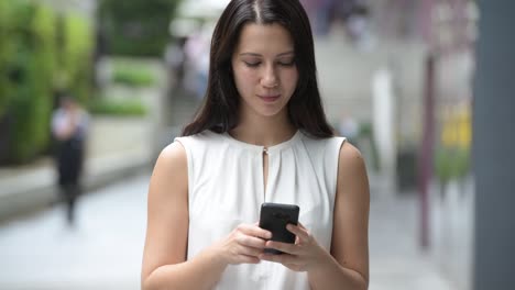 Porträt-von-schönen-jungen-glücklich-Frau-im-Freien-mit-Handy