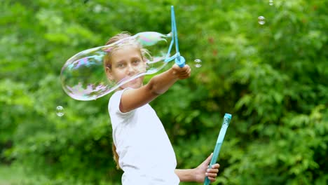 Kleines-Mädchen-spielt-mit-Seifenblasen-im-Freien.-Slow-Motion.