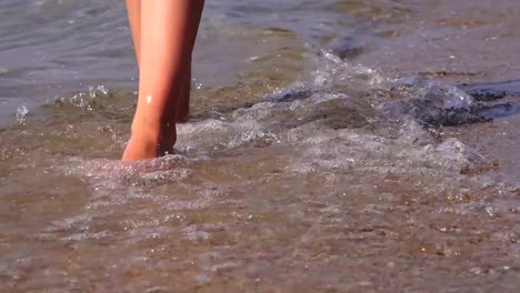 Beautiful-female-feet-walking-along-the-sea