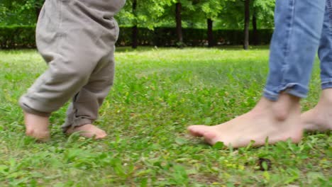 Barfuß-Mutter-Lehre-Baby,-Spaziergang-im-Park