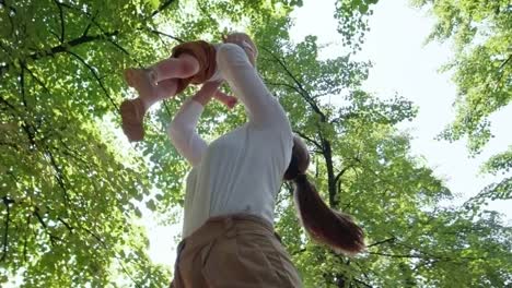 Mother-Throwing-Baby-Boy-in-Air-Outdoors