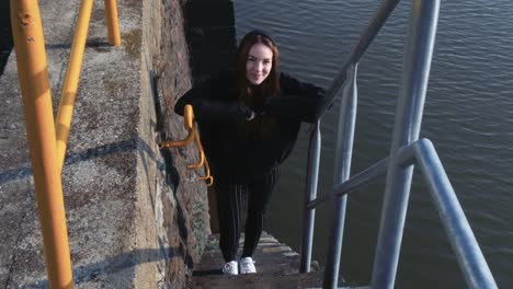 Young-Smiling-Woman-Standing-on-River-Staircase