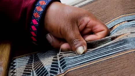 Close-up-of-a-man-hands-weaving-on-a-loom-as-his-ancestors-used-to-do