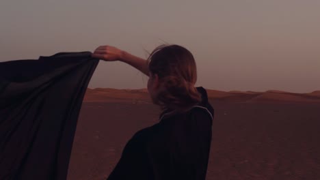 Mujer-musulmana-de-pie-cerca-de-la-mezquita-en-el-desierto.-Viento-fuerte-Paz-de-Oriente-Medio-sin-guerra