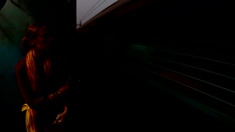 woman-near-open-doors-in-moving-train-railway-of-Kolkata-evening