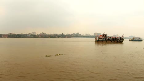 two-ferry-boats-float-on-full-flowing-river-Hoogli-buildings-of-city-Kolkata-on-bank