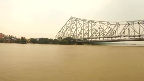 Howrah-Bridge-Blick-von-schwimmenden-Boot-im-Bau-Gebäude-der-Stadt-Kalkutta-am-Ufer