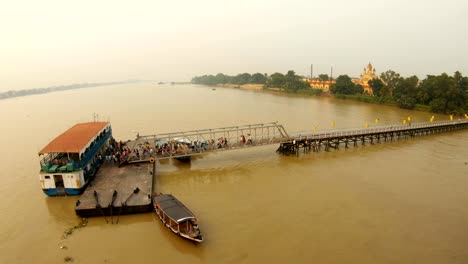 Pier-verladen-Passagiere-an-Bord-Fähre-Kali-Mata-Tempel-am-Ufer-des-Flusses-Hooghly-Top-View-Ramakrishna-Mission-Kolkata-Sonnenuntergang