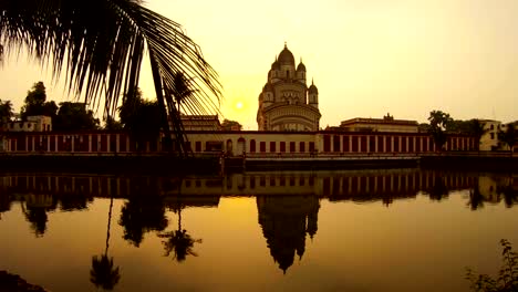 Hermosa-puesta-de-sol-cerca-de-Dakshineswar-estanques-del-templo-reflejo-en-la-superficie-espejo-de-las-palmas-de-agua-Misión-Ramakrishna