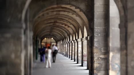 Tourists-walking-at-Place-de-Vosges-in-Paris,-tilt-shift