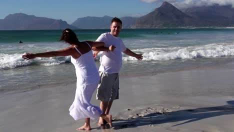 Slow-motion-of-romantic-couple-spinning-around-on-the-beach,-Cape-Town,South-Africa