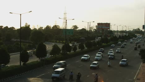 Locked-on-shot-of-traffic-moving-on-city-street,-Delhi,-India