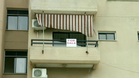 For-sale-sign-on-apartment-balcony.-Real-estate-agency-services.