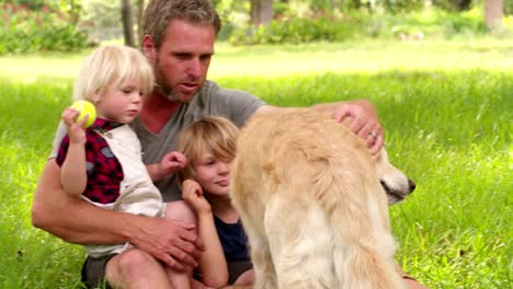 Dad-plays-with-his-cute-sons-and-their-dog-outside